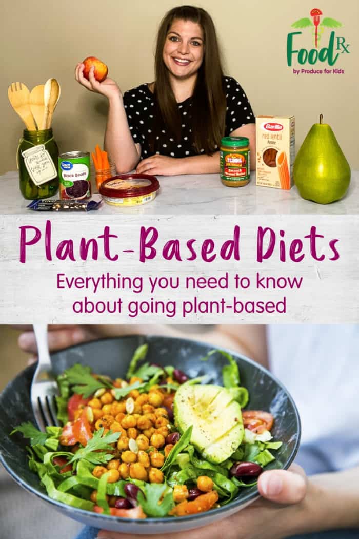 Woman holding apple with vairous plant-based food items like beans, hummus and pasta, in front of her on counter. 