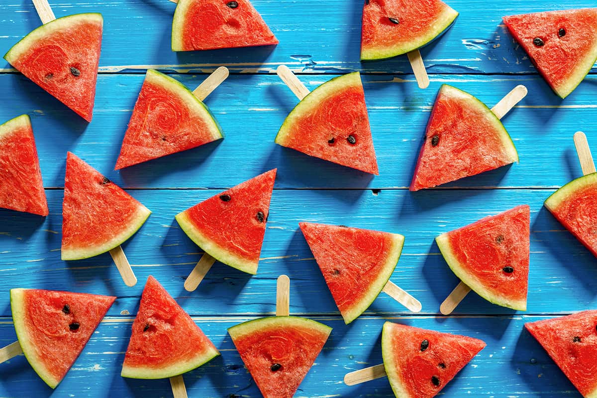 Watermelon slice popsicles on a blue rustic wood background
