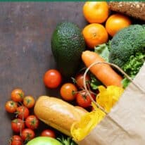 Paper grocery bag spilling over with fresh produce with text overlay