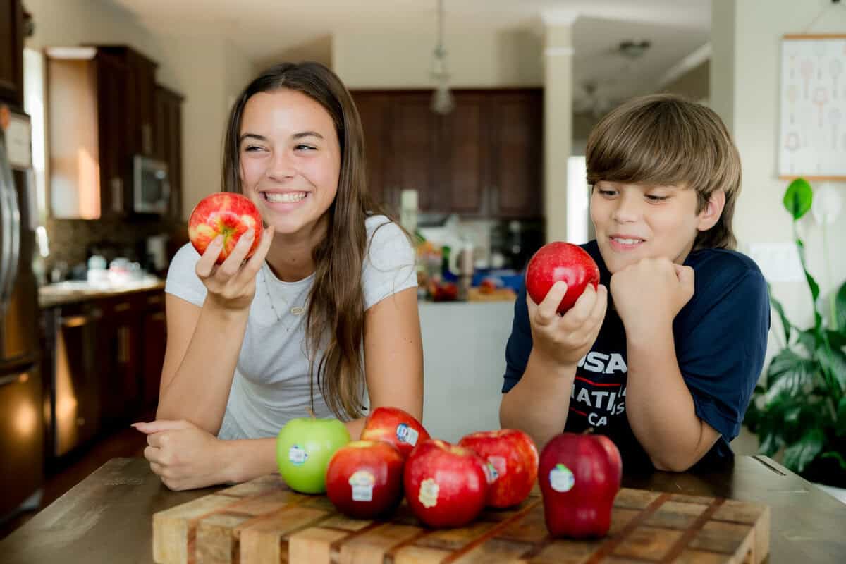 Young kids holding red apples.