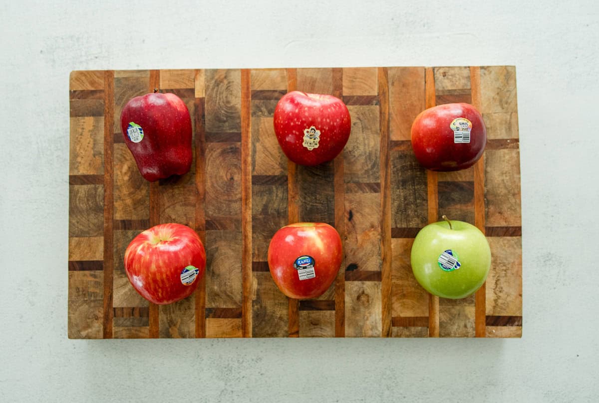 Different apples over a cutting board.