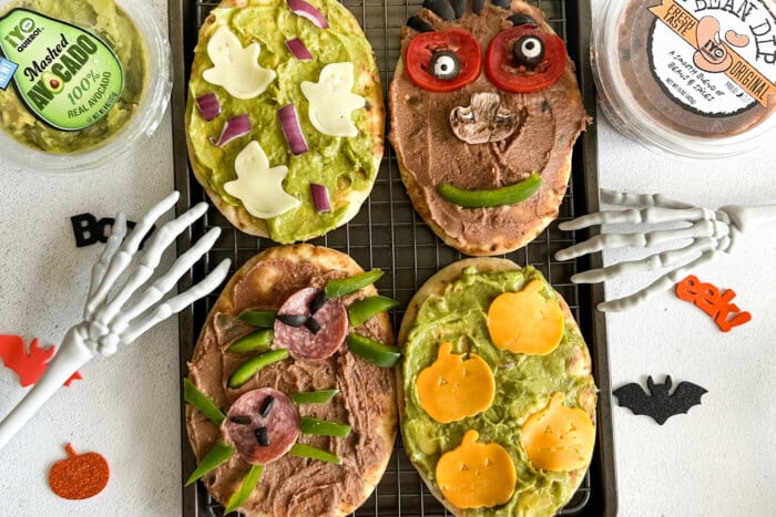 Flatbreads with Halloween spooky decorations like cheese ghosts and salami spiders.
