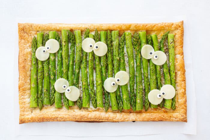 Flatbread with cheese and asparagus decorated with silly eyeballs