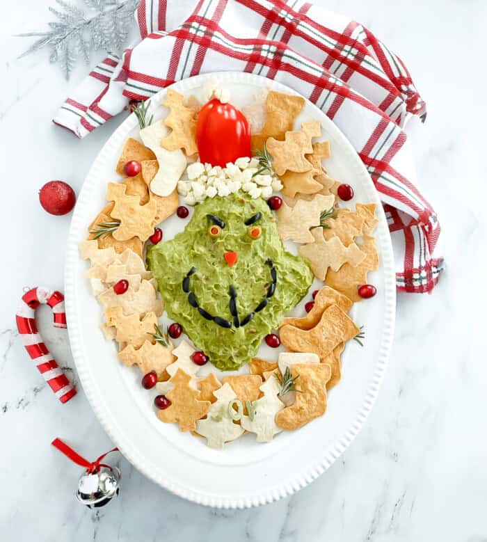 Grinch-inspired guacamole display with Christmas decorations.