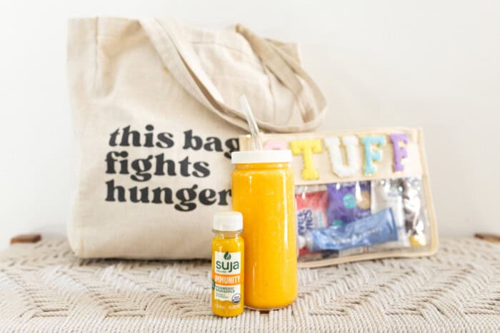 Suja Immunity Shot, turmeric, and Pineapple flavor, next to an orange juice drink.